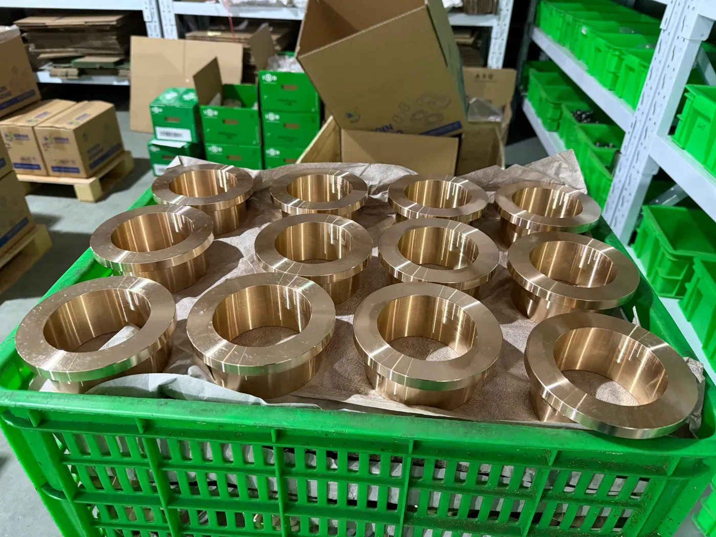 Machined bronze bushings in a basket awaiting inspection