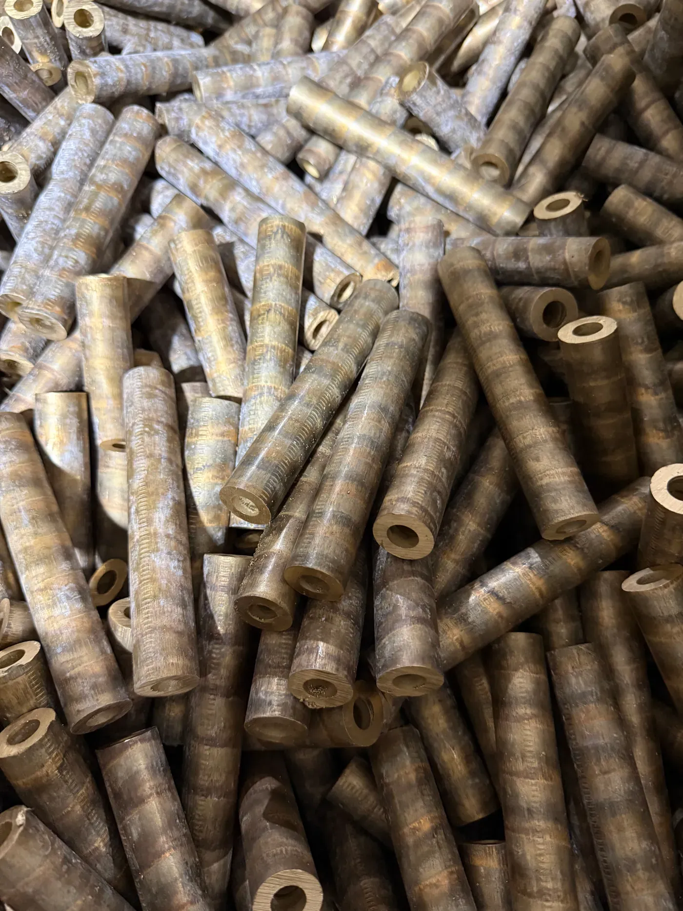 Continuous-cast bronze tube stock stacked before machining