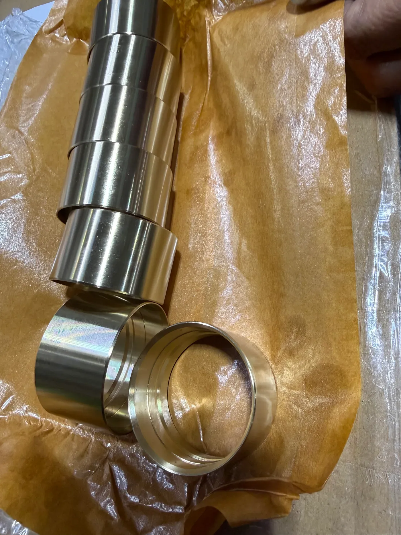 Freshly machined cast bronze bushings on kraft paper
