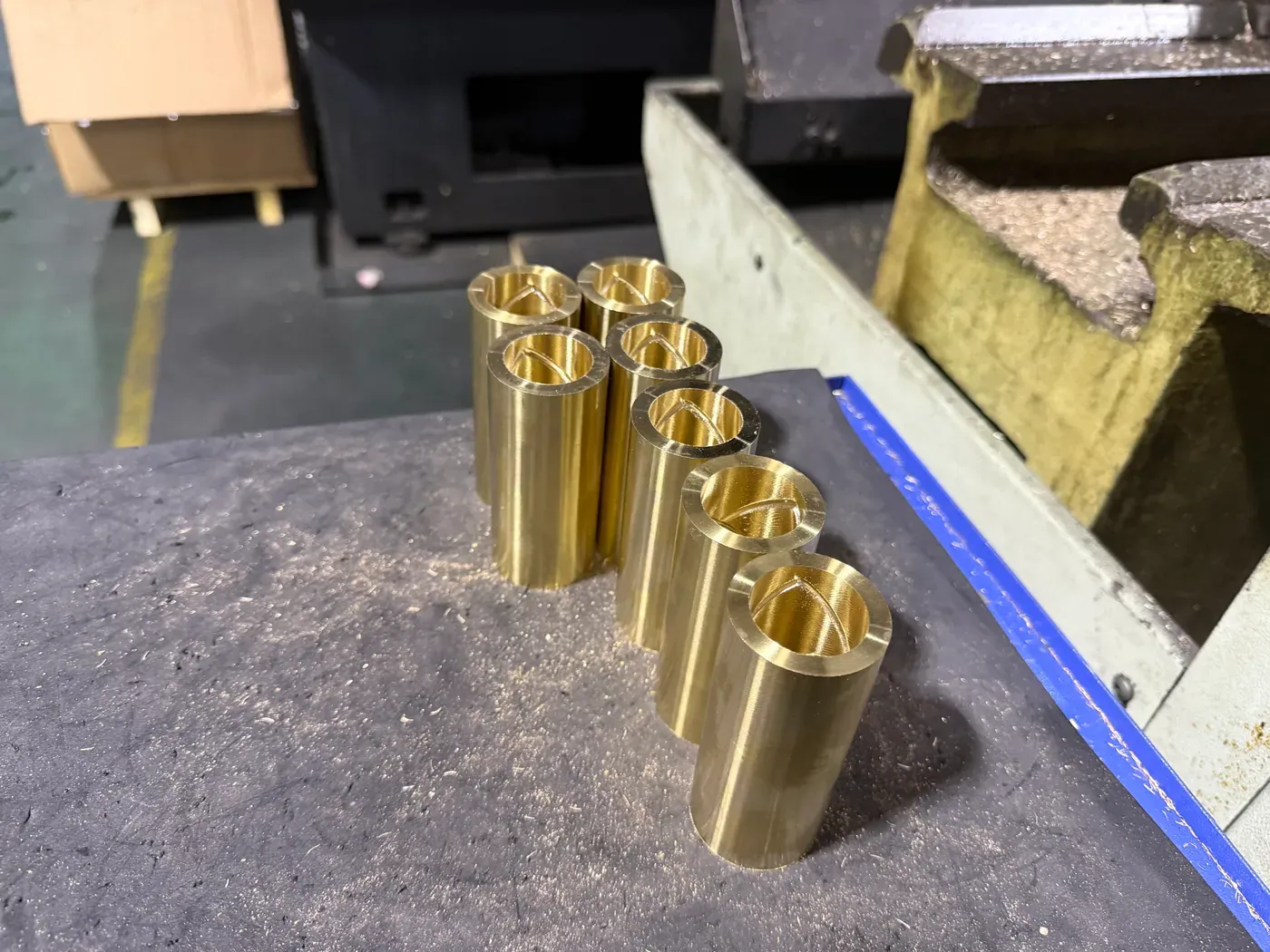 Small cast bronze bushings with oil holes on a lathe table